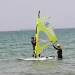 מדריך גלישת רוח של Surf Cycle מלמד ילד על גלשן רוח בים מדריך גלישת רוח של Surf Cycle מלמד ילד על גלשן רוח בים