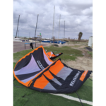 קייט משומש RRD Religion 7 מטר בצבעי שחור-כתום על הדשא בחוף הים